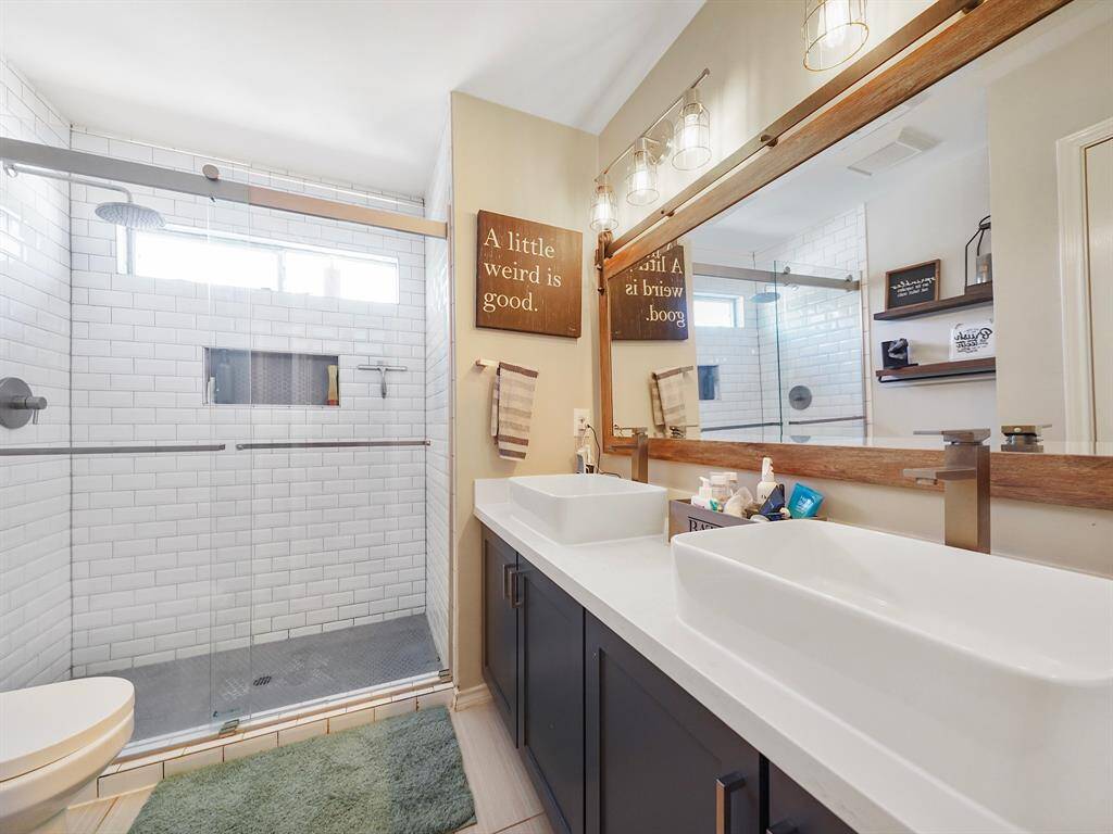 beautifully updated secondary bathroom upstairs. Highlights include an expansive vanity with ample storage, dual vessel sinks, a framed mirror, and an oversized shower. Enjoy a modern and luxurious space perfect for relaxation and convenience. A true highlight of the home.