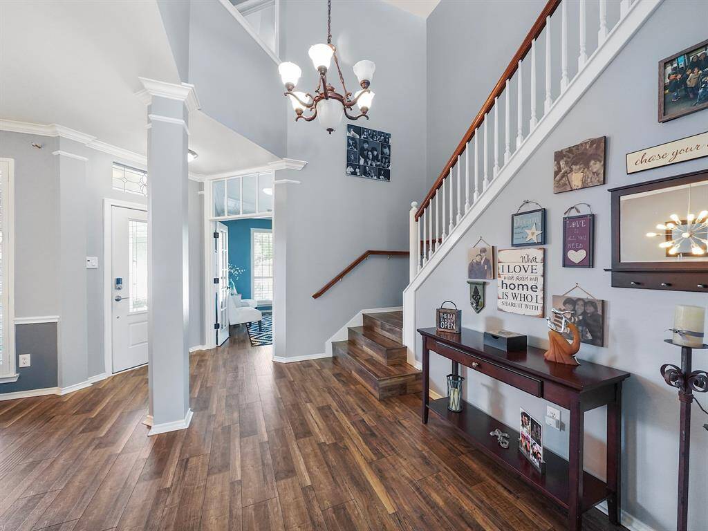 The elegant entryway highlights the home's exquisite details, including crown molding and a stunning light fixture.