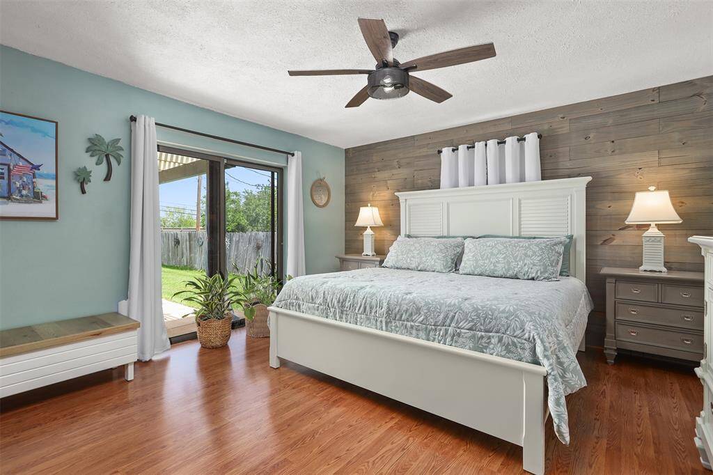 Primary bedroom with a covered porch behind the glass doors. Notice the custom wall treatment.