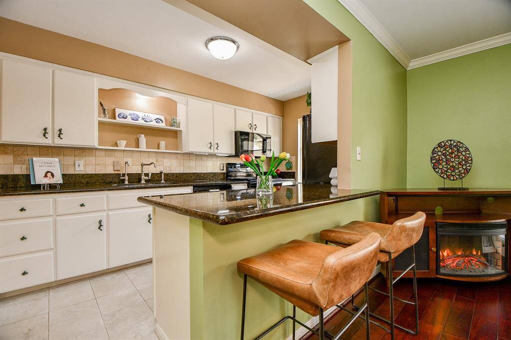 Refurbished kitchen with granite counters and a breakfast bar.