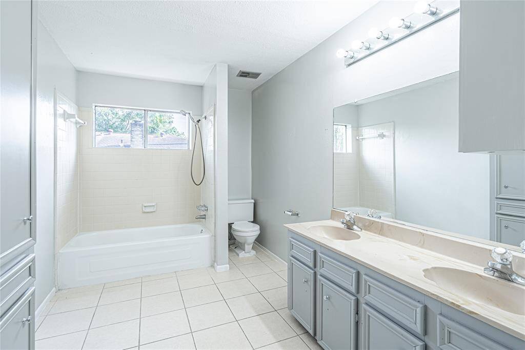 Primary bath featuring a tub/shower combo, double vanity, and freshly repainted cabinets for a modern feel.