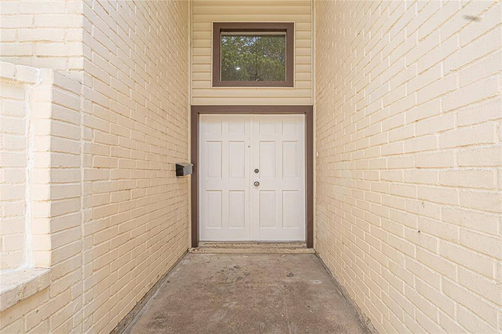 Welcoming front doors set behind a brick wall, providing added privacy and a great first impression.