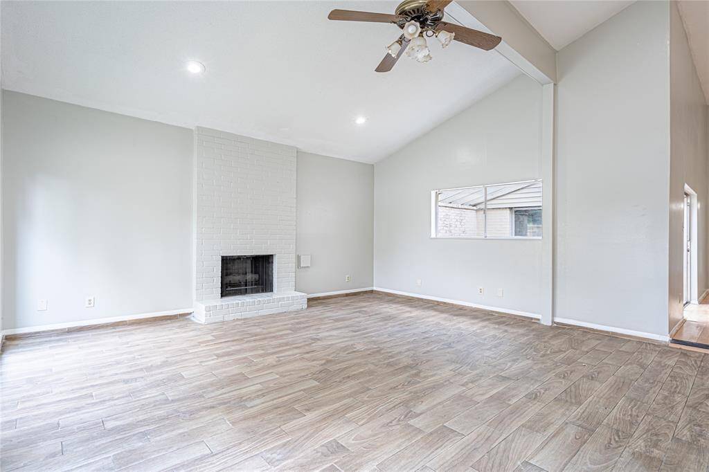 Spacious family room with high ceilings, a fireplace, and windows overlooking the peaceful courtyard... perfect for relaxing or entertaining.