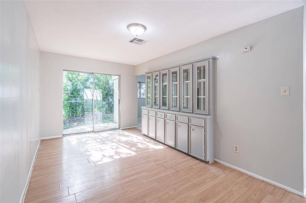 Enjoy meals in the formal dining room featuring a built-in hutch and easy access to the backyard through sliding glass doors.