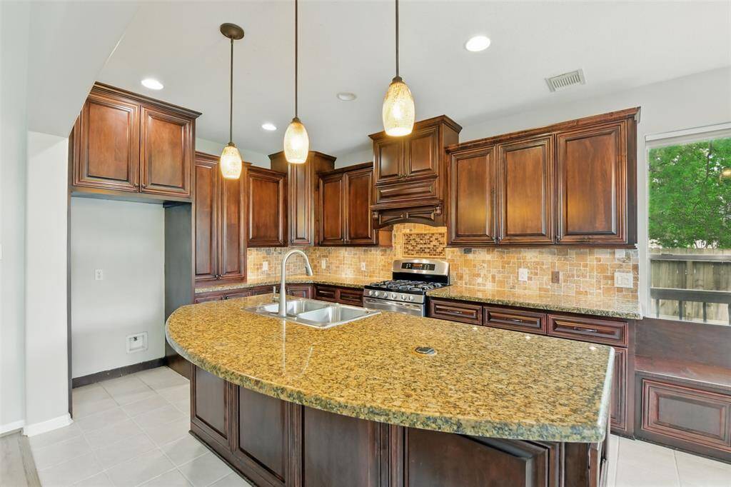 Grab your barstools and enjoy a meal around the large kitchen island, complete with double basin sinks.