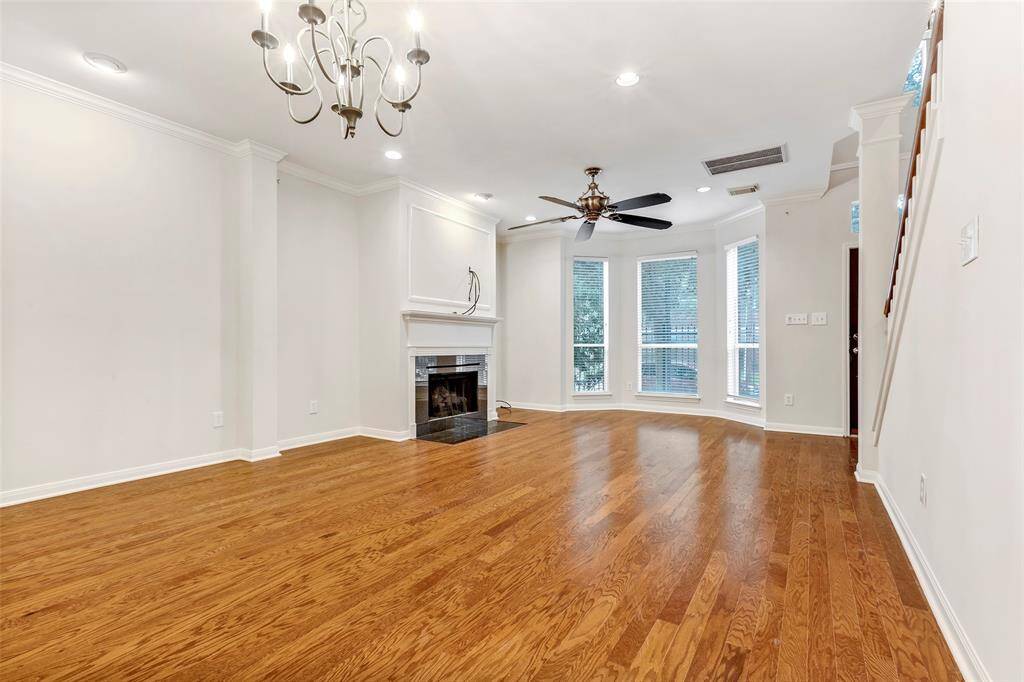 A wider view of the empty living area, bathed in natural light from the large windows.