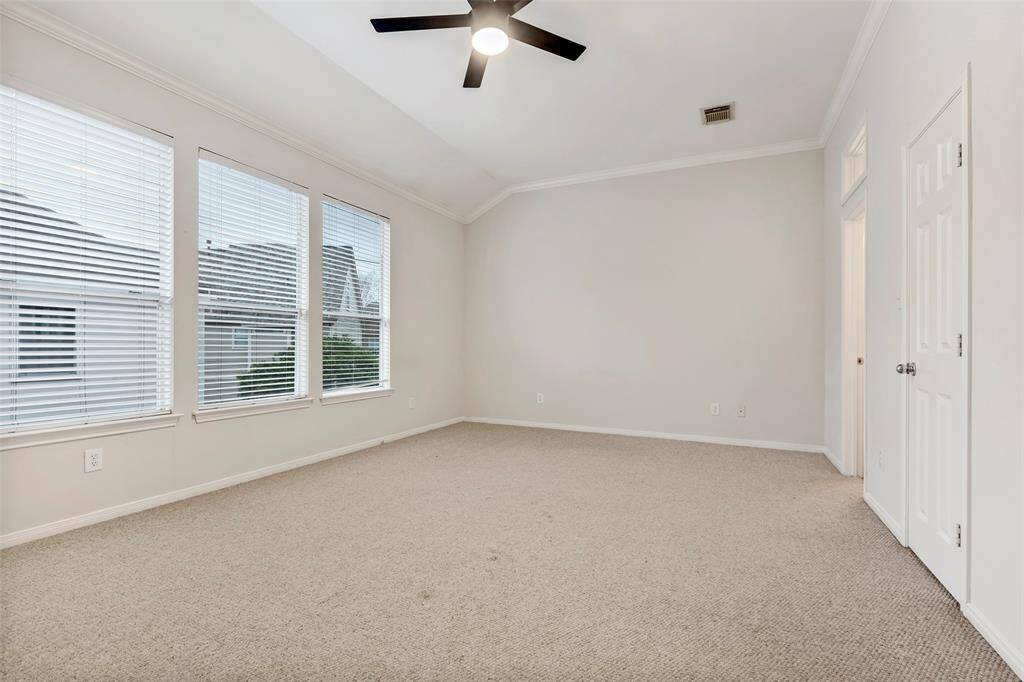 Another primary bedroom featuring large glass windows and carpeted floors—imagine the possibilities for creating your perfect retreat.