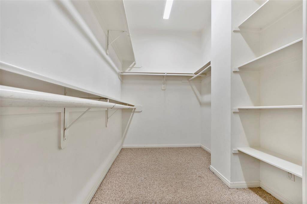 Generous walk-in closet with built-in shelves.