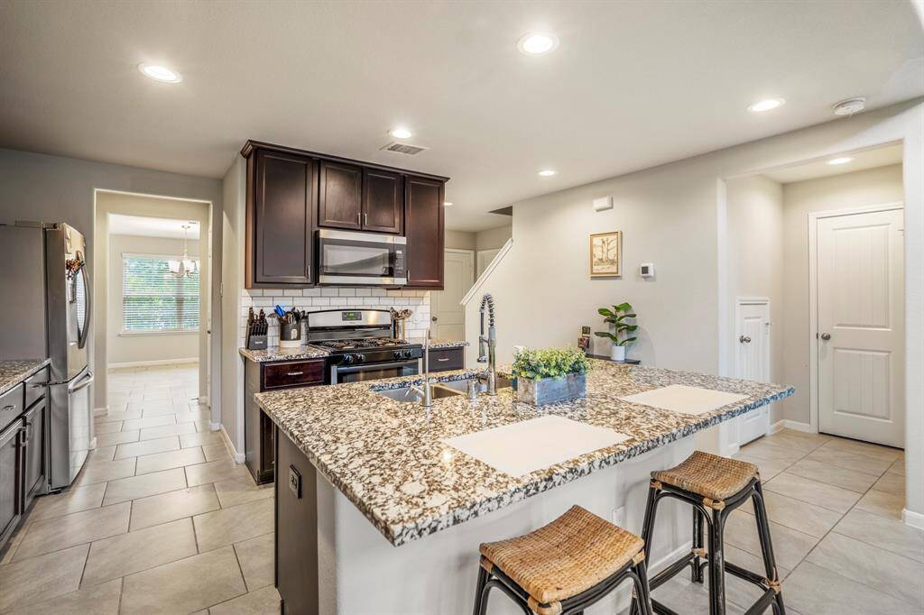 Another view of the kitchen area showing the stove and microwave.