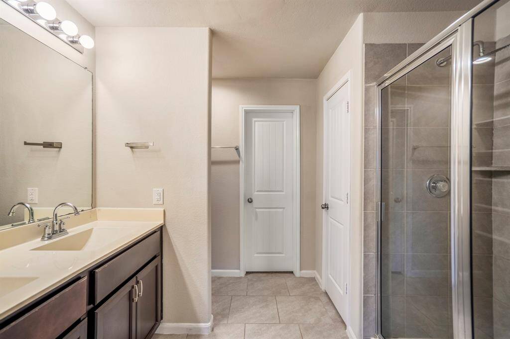 Dual sinks, and a glass enclosed shower are on offer in the en-suite bathroom.