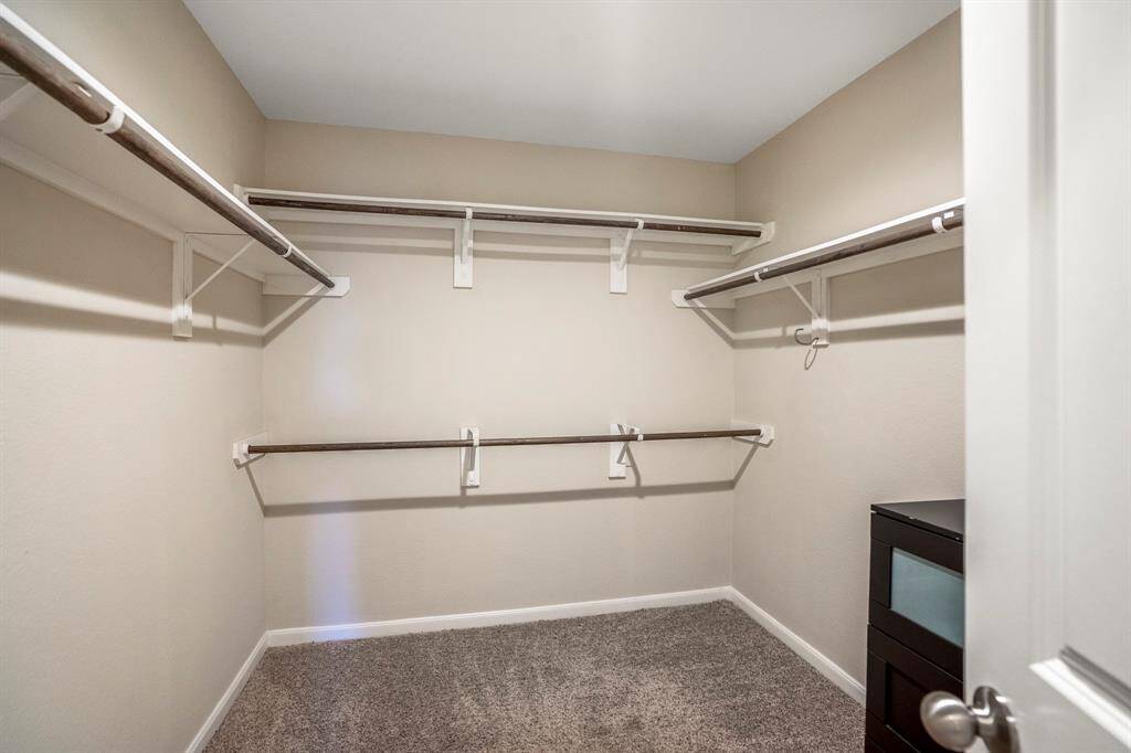 A large walk in closet offers lots of hanging space in the primary bedroom suite.