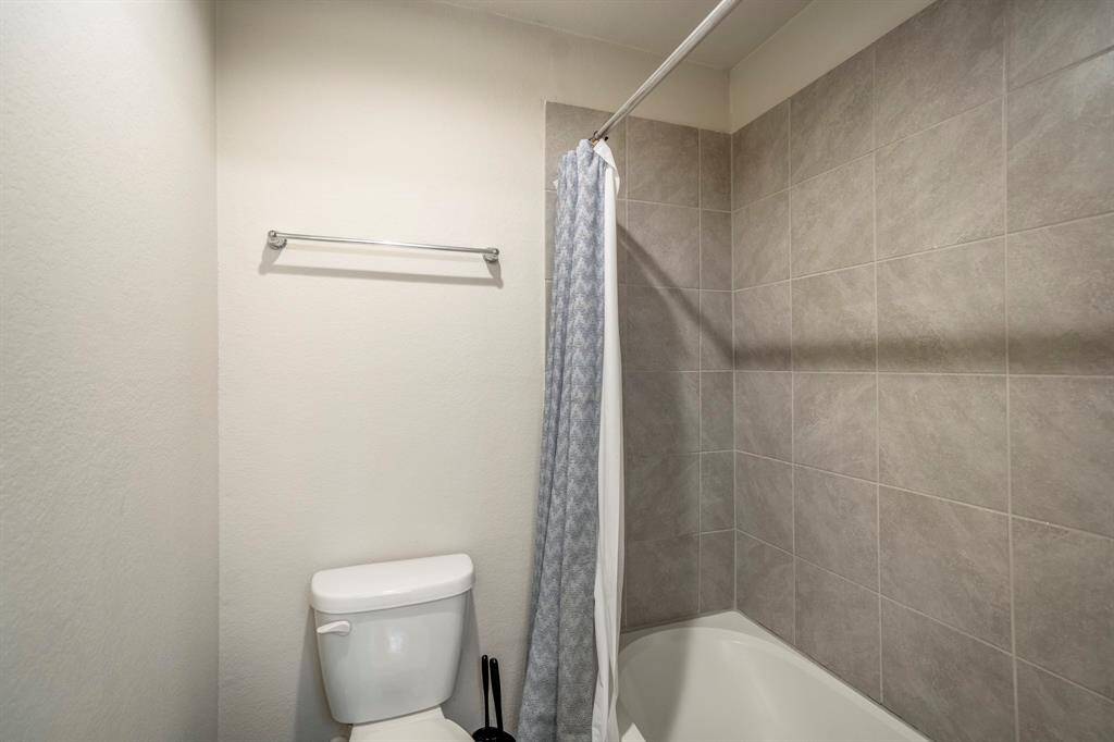 The secondary bathroom offer neutral tones, with a tub / shower combo.