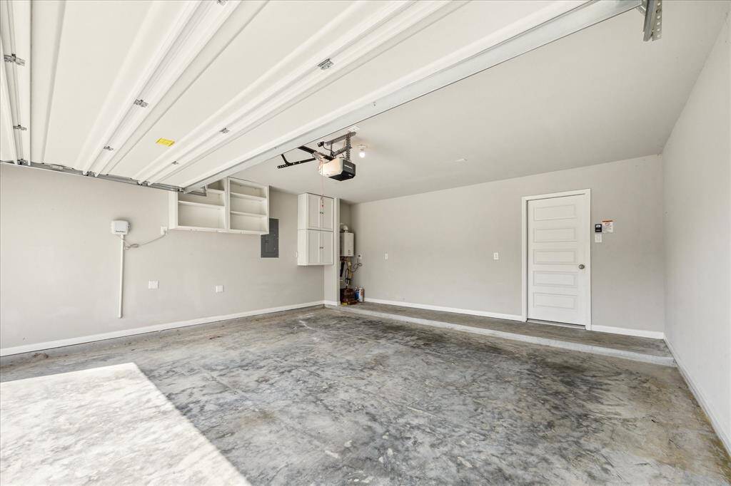 Garage with cabinets and tankless water heater