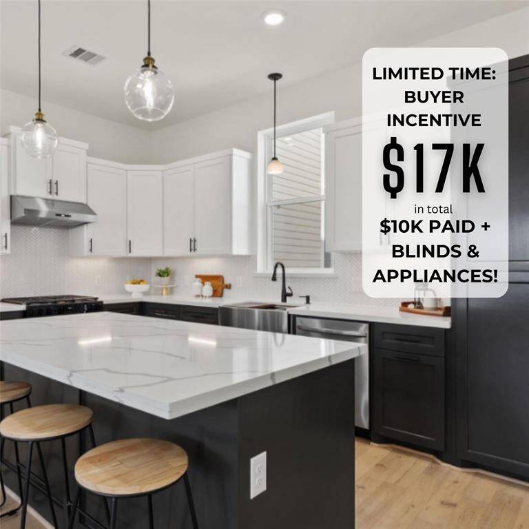Modern kitchen featuring white countertops, a central island with seating, sleek dark cabinetry, stainless steel appliances, and pendant lighting.