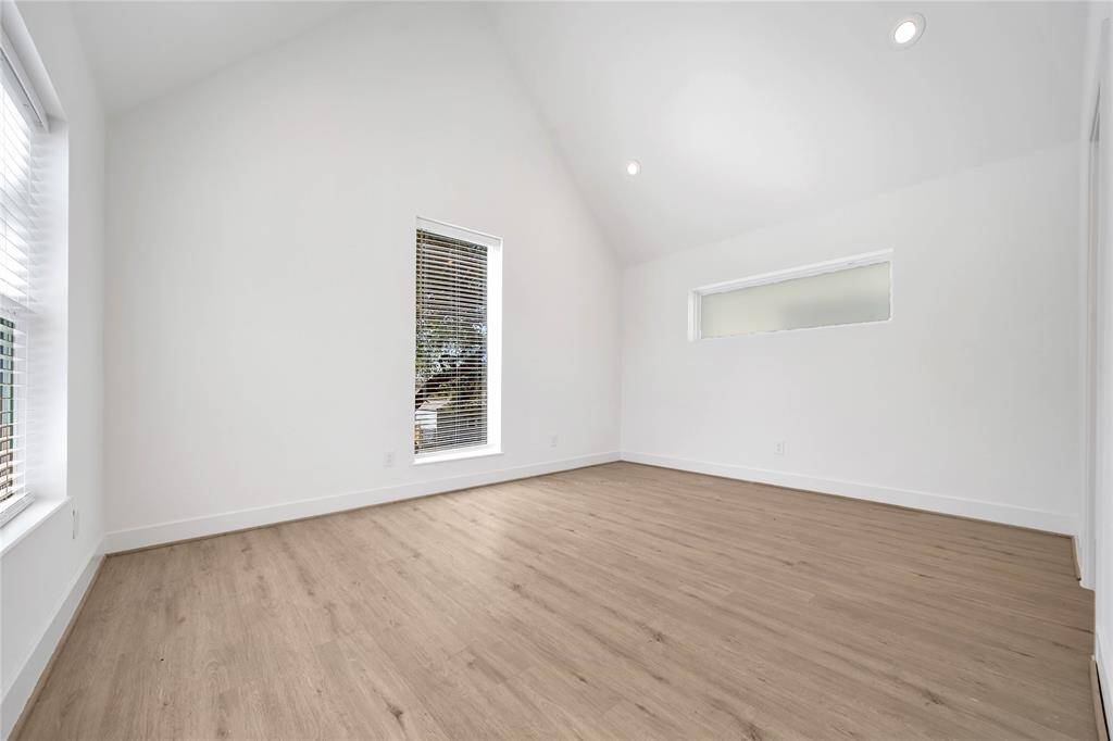 Primary bedroom with vaulted ceilings and beautiful windows.