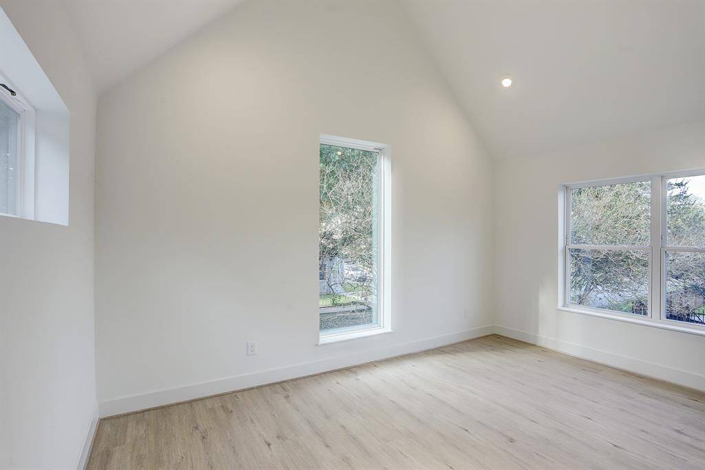 Primary bedroom with vaulted ceilings and beautiful windows.
