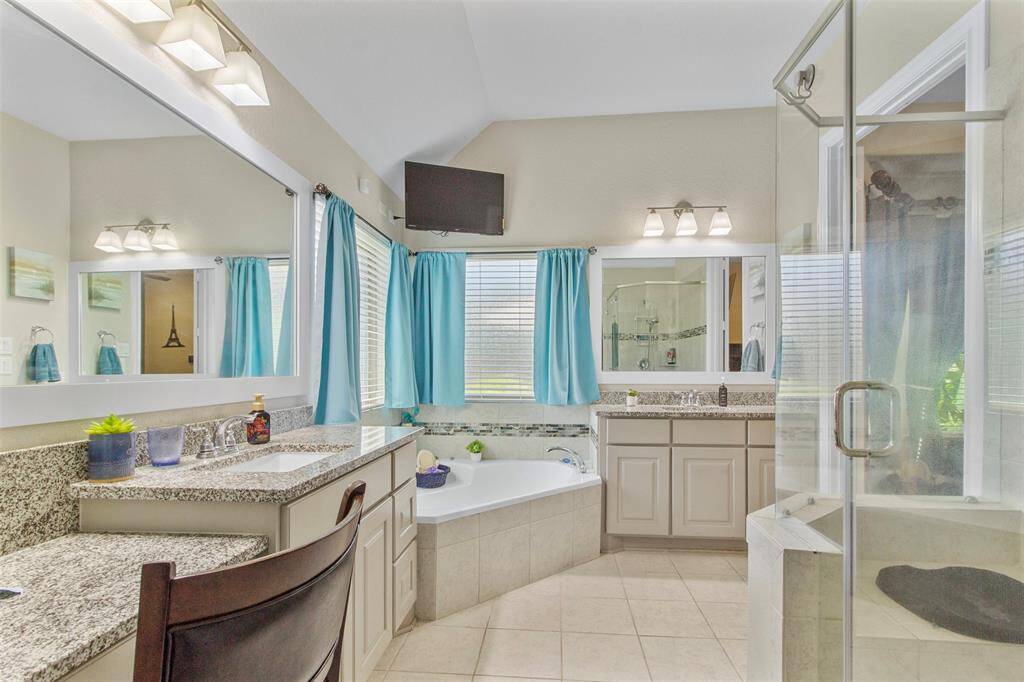 Primary bath has separate dual vanities, separate tub and shower and tons of counter space.