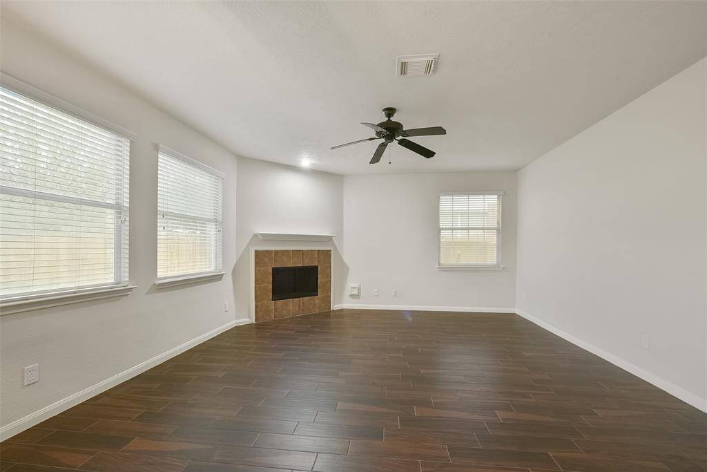 The family room with a corner fireplace is located just off of the kitchen and breakfast room area.