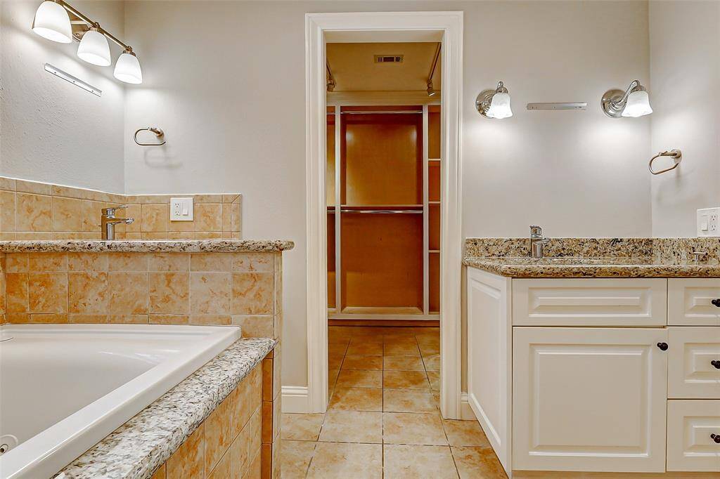 Continuing past the vanities, you’ll discover your expansive walk-in closet—offering plenty of space for all your wardrobe essentials.