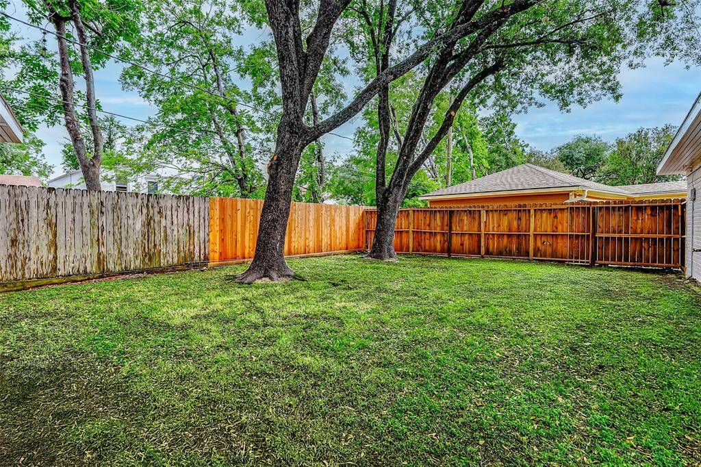 The expansive backyard offers plenty of space for play, gardening, and entertaining loved ones. Towering trees add natural shade, making this outdoor space both functional and inviting.