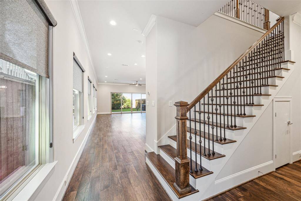 A bright and inviting entryway with an open flow, featuring hardwood floors, recessed lighting, and a glimpse of the main living areas.