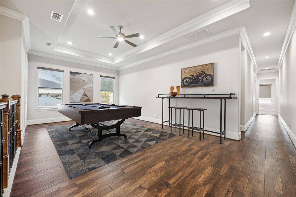 **Virtually Staged** The spacious second-floor game room has recessed lighting, ceiling fan, crown molding, and large windows providing ample natural light.