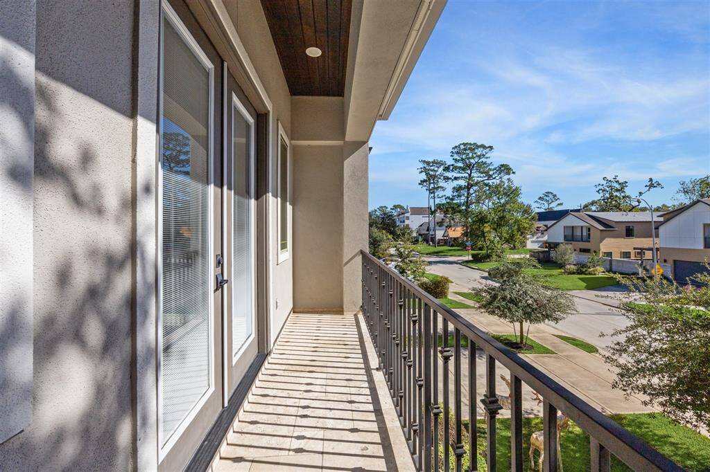 A private balcony accessed from the primary suite, offering a tranquil outdoor space with views of the lush landscaping.