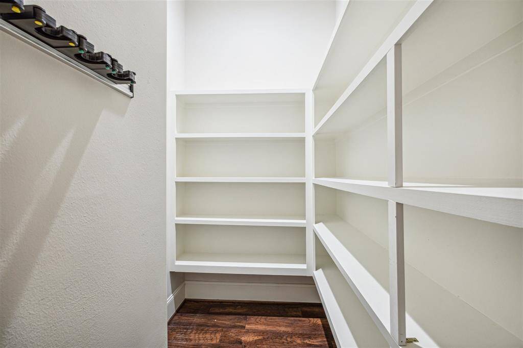 Spacious walk-in pantry with custom shelving to accommodate all your storage needs.