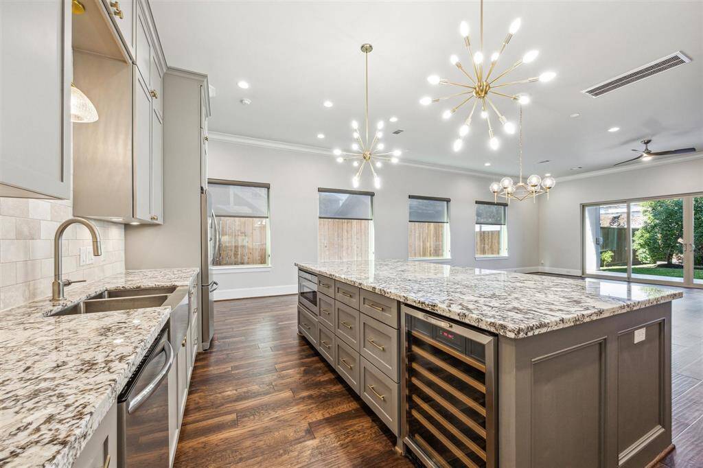 Beautiful granite countertops throughout the kitchen with a large island with built-in wine storage and microwave, and ample storage space for functionality and style.