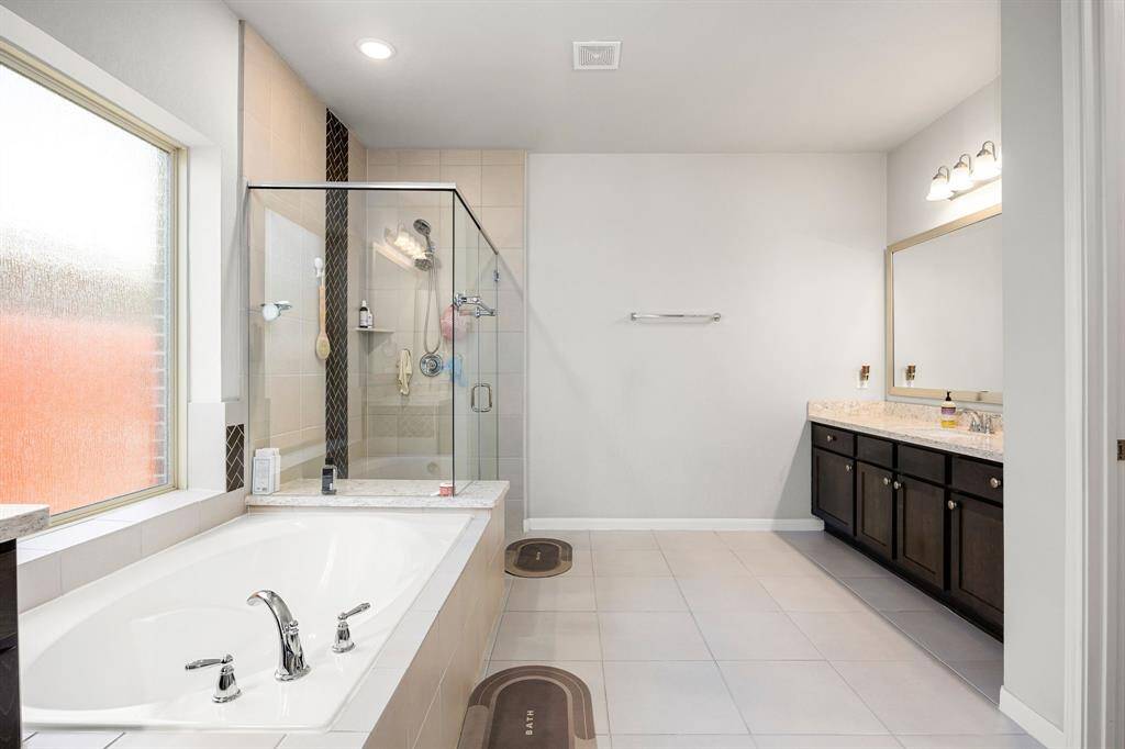 Discover your private sanctuary in the owner's en-suite, featuring dual vanities, a spacious walk-in closet, and a luxurious separate tub and shower.