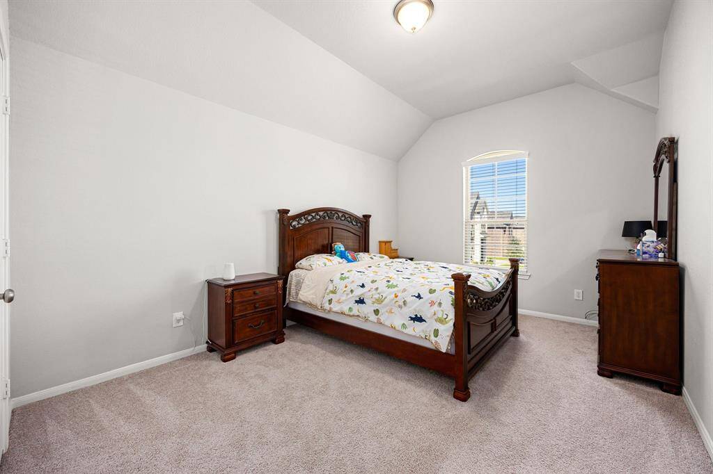 Spacious third bedroom with plush carpeting, abundant natural light, and room for versatile furniture arrangements.