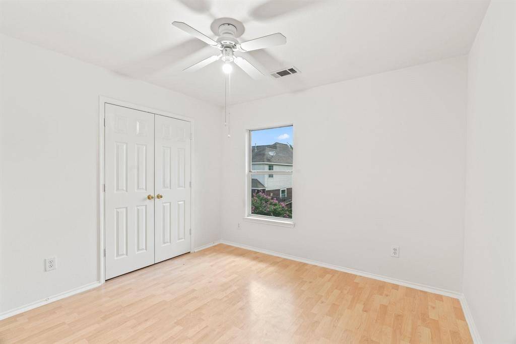 Secondary bedroom with ceiling fan and large closet