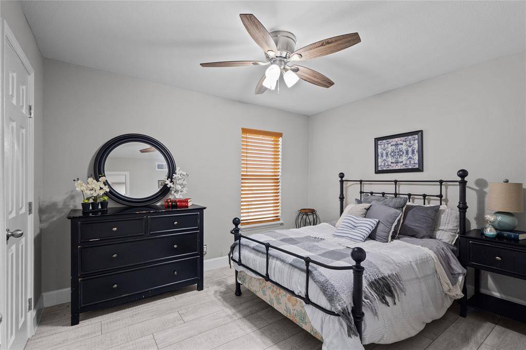 The spare bedroom has white/grey vinyl plank faux wood flooring, fresh paint, nice wooden blinds for window, a ceiling fan to keep the bedroom extra cool, and a large closet!