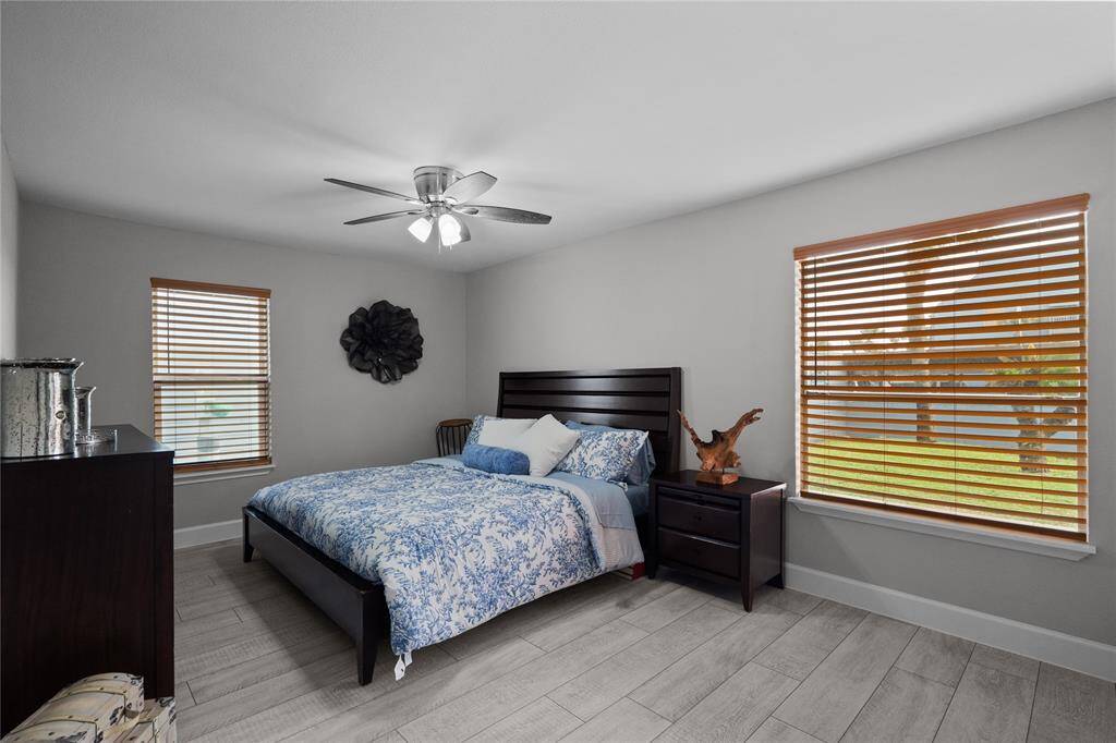 The master bedroom is very spacious, has grey/white, faux wood vinyl plank flooring, fresh paint, bid windows with nice wooden blinds, ceiling fan to keep thebedroom extra cool, and modern fixtures and finishes.