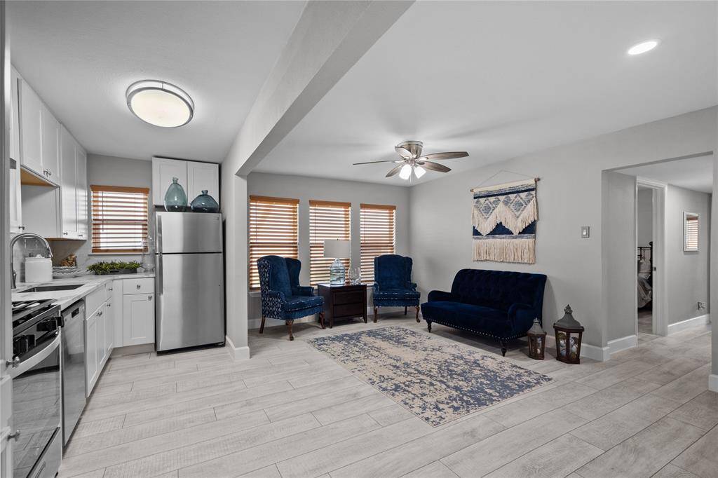 The living/kitchen/dining area has grey/white faux wood vinyl plank flooring, quartz countertops in kitchen, stainless steel appliances, white cabinets with white/grey subway tile backsplash, fresh paint and modern fixtures and finishes!!