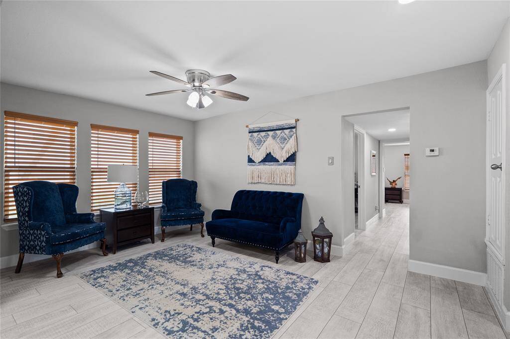 The living room has lots of large windows with nice wooden blinds. There is also a ceiling fan to help keep the home extra cool!