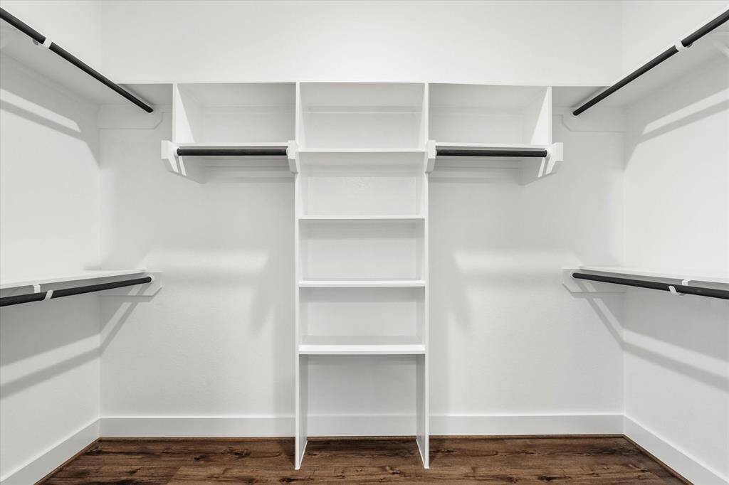 The primary walk-in closet, thoughtfully designed with custom shelving and cabinetry, offering ample storage and organization for your wardrobe.