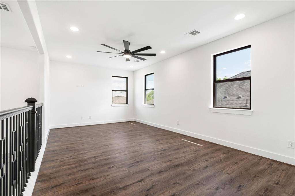 The second floor features a spacious flex area, ideal for gaming, relaxing, or unwinding in your free time. It includes a ceiling fan, recessed lighting, and an abundance of natural light from multiple windows.