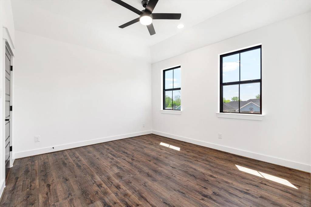 Secondary bedroom features a closet, ceiling fan, recessed lights, wood look tile flooring & 2 windows.