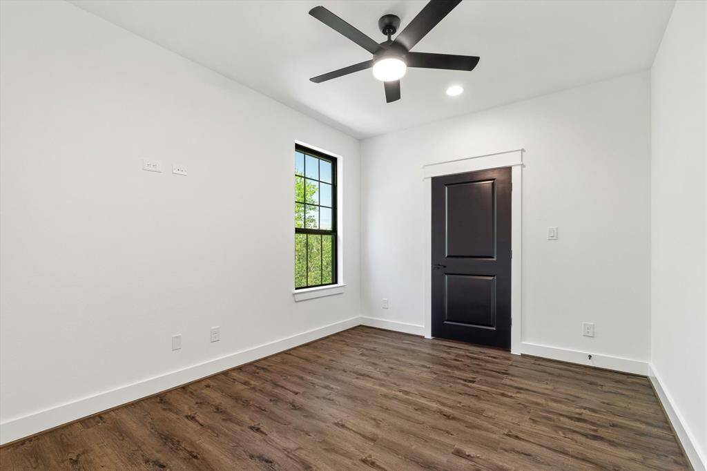 Bedroom 4, like the other bedrooms, offers a ceiling fan, a large window, a generous closet, and wood-look tile flooring throughout.