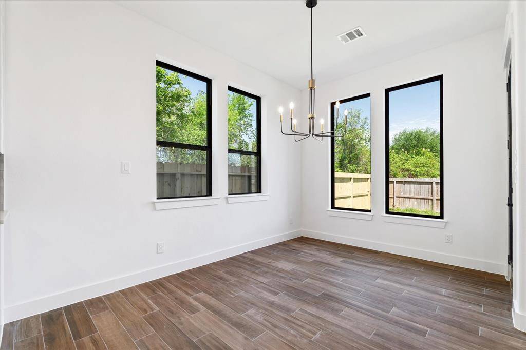 The spacious dining area features picture windows and a charming fixture, creating an ideal space for shared meals.