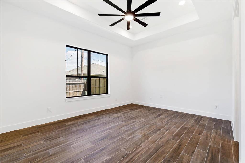 Your primary bedroom on the 1st floor! Features large windows, a ceiling fan, a tray ceiling, and plenty of space for king-sized furniture.