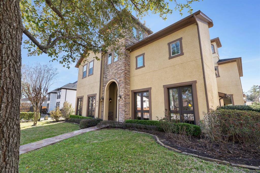 Wrought iron fenced-in front yard with green space for kids/pets to play. Landscaping and mature trees.