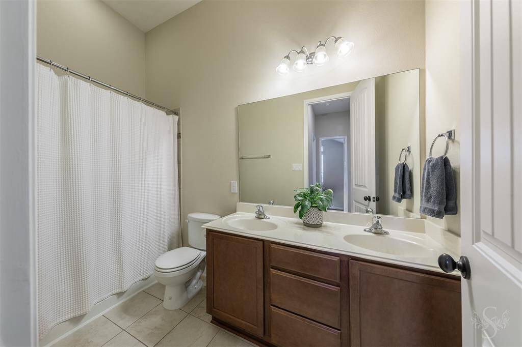 Secondary bathroom.  Double sinks and tub/shower. Ample storage under sink.