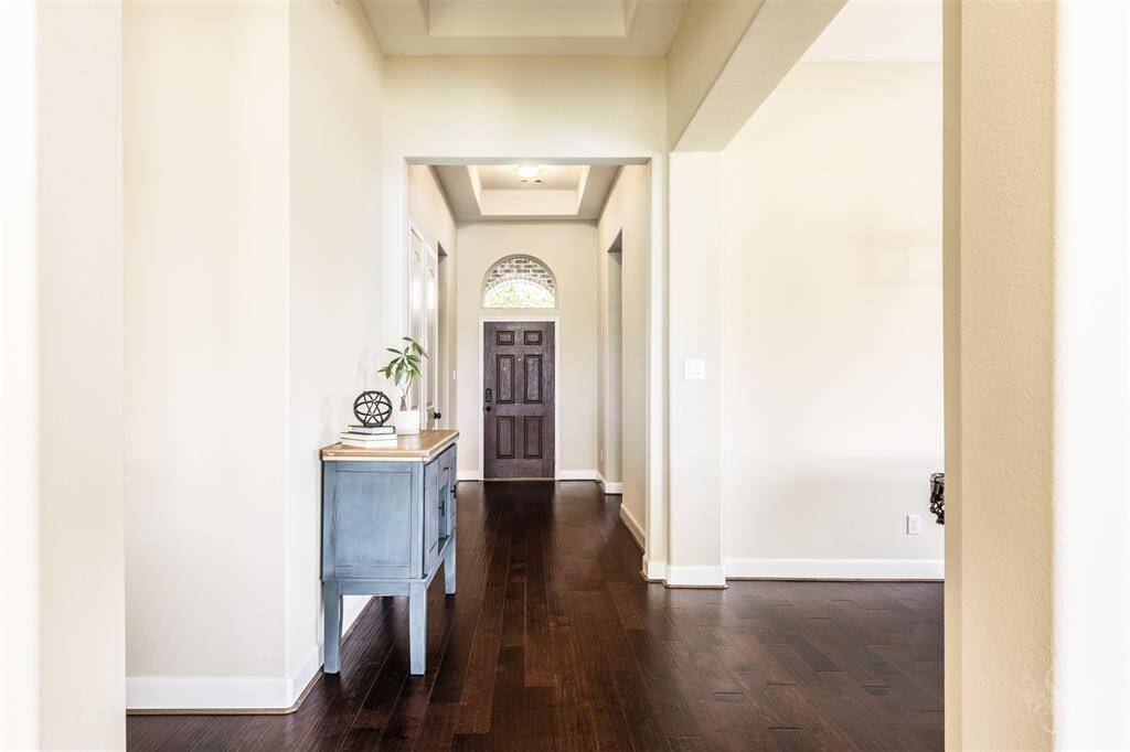Beautiful entry with tray ceiling and gleaming hardwood floors.