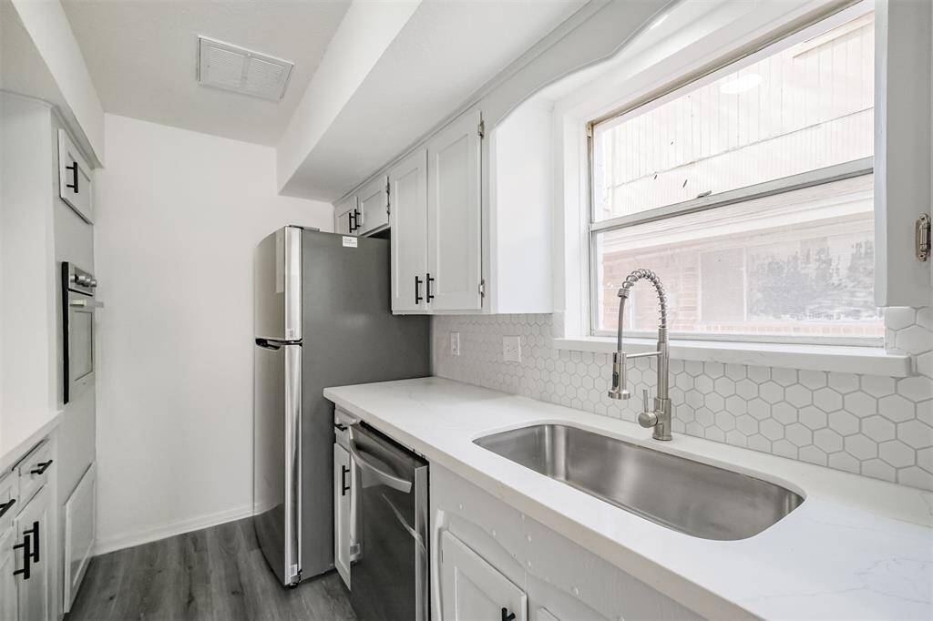 Undermount farmhouse sink with a tiled backsplash.