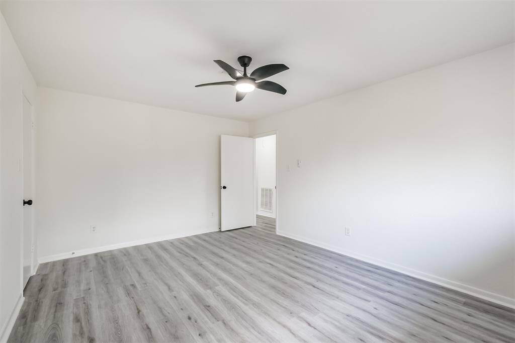 Primary bedroom featuring a ceiling fan and an elegant light fixture.