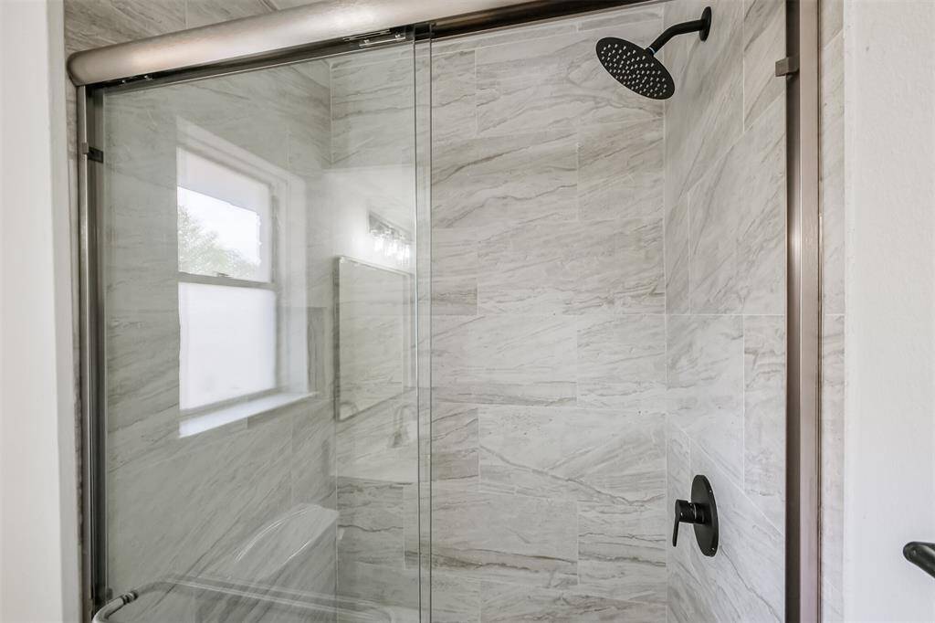 An elegant walk-in shower featuring exquisite ceramic tile.