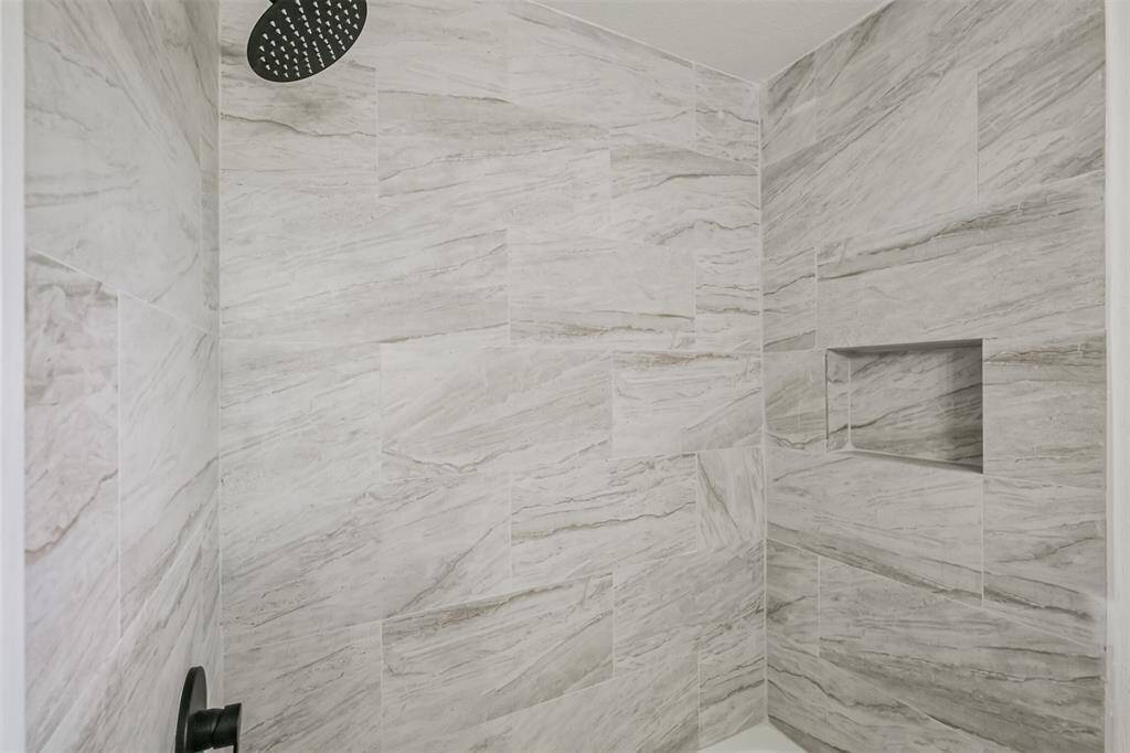 The hall bathroom features a ceramic tile-enclosed tub and shower.