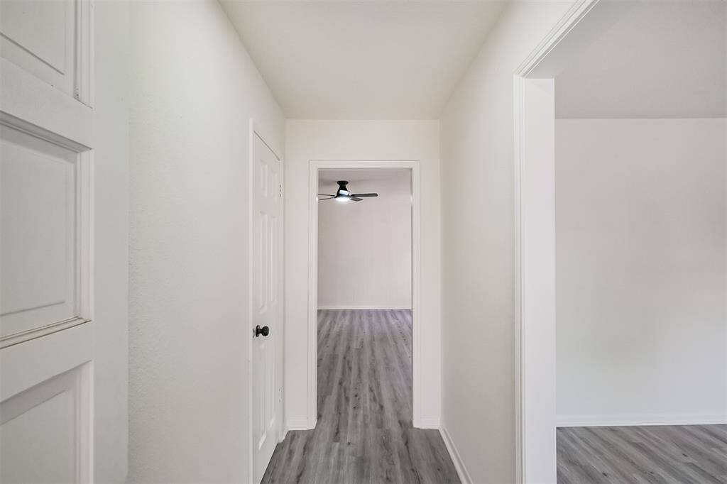 A sturdy solid wood front door complements the elegant wood-look vinyl plank flooring that extends throughout the home.